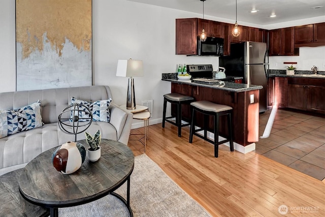 living room featuring light wood finished floors, recessed lighting, and baseboards