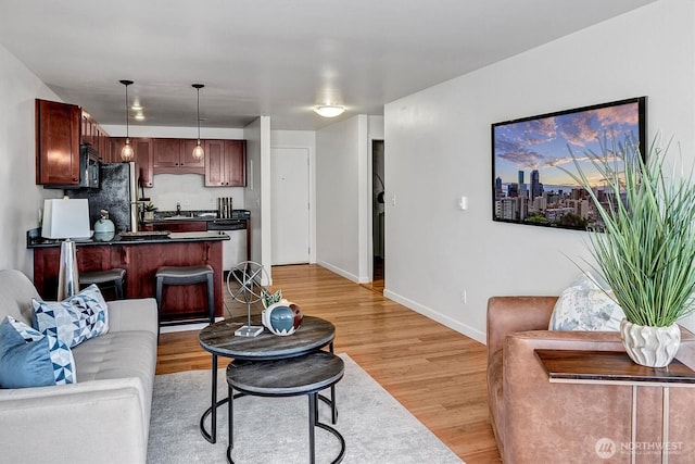 living area with baseboards and light wood-style floors