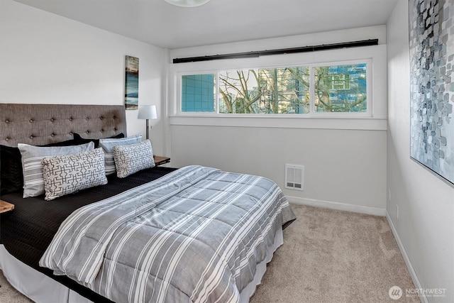 carpeted bedroom with visible vents and baseboards