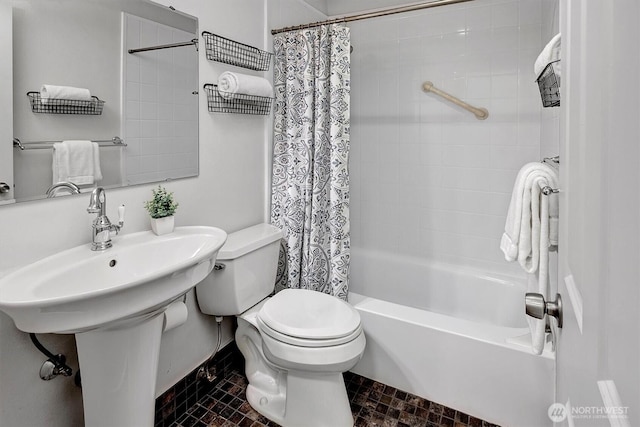 bathroom featuring toilet, shower / tub combo with curtain, and a sink