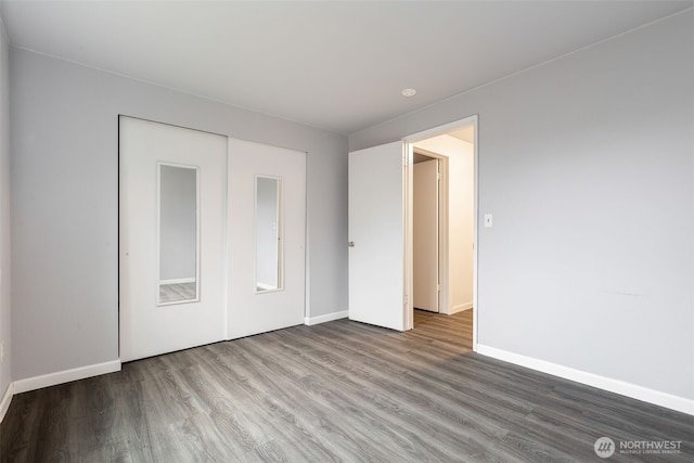 unfurnished bedroom with a closet, baseboards, and wood finished floors