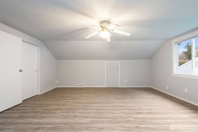 bonus room featuring lofted ceiling, light wood-style flooring, visible vents, and ceiling fan