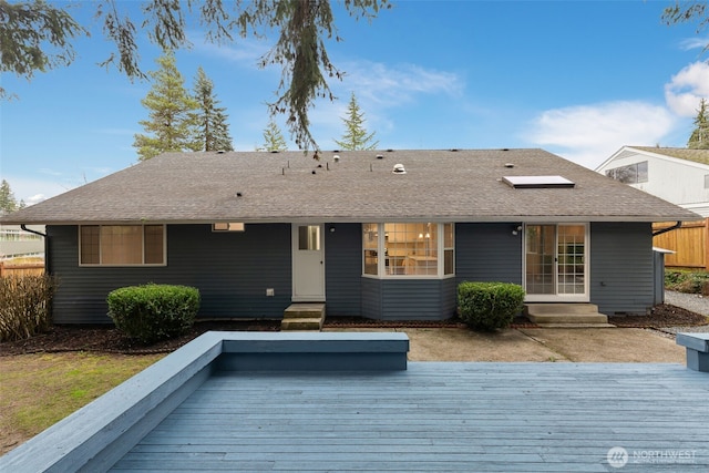 view of front of property with entry steps, roof with shingles, and a wooden deck