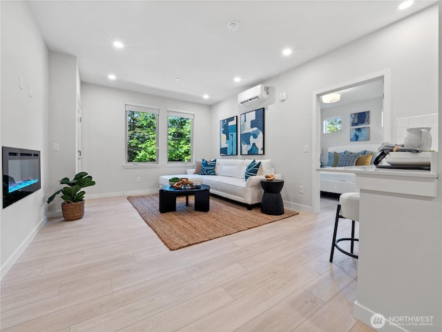 living area featuring baseboards, an AC wall unit, recessed lighting, and light wood-style floors