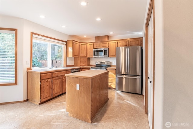 kitchen with a kitchen island, recessed lighting, a sink, stainless steel appliances, and tile counters