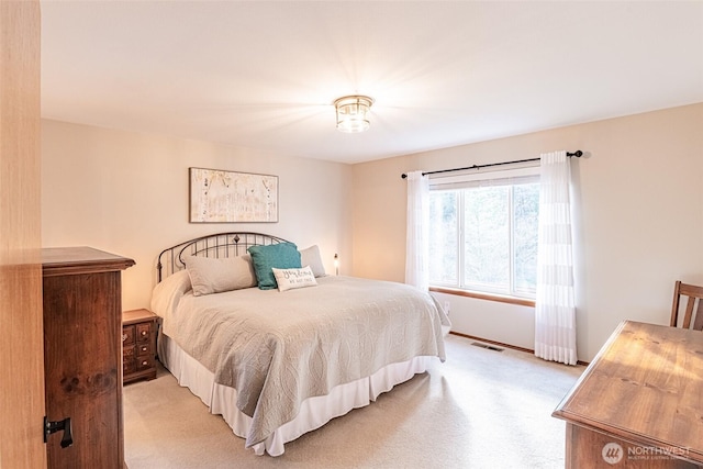 bedroom with visible vents and light carpet