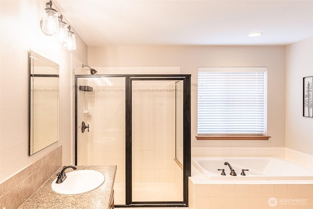 full bath featuring vanity, a garden tub, and a stall shower