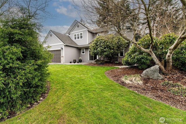 back of property with a lawn, driveway, and a garage