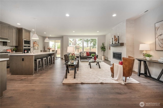 15814 Boise Ln SE, Yelm, WA 98597 - living area with a tile fireplace, dark wood-style flooring, visible vents, and recessed lighting