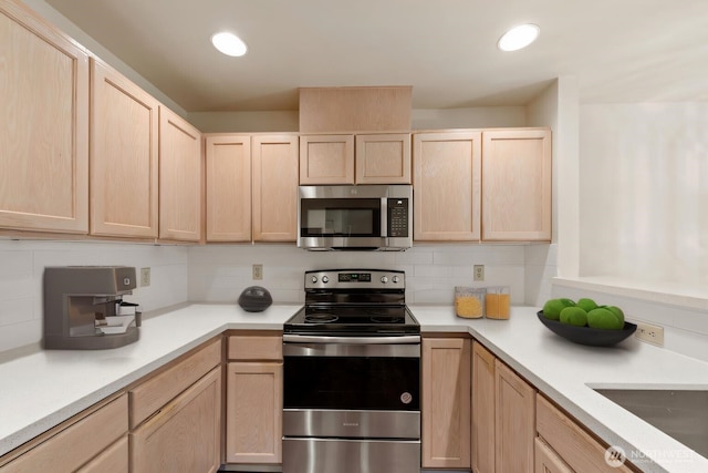 kitchen with appliances with stainless steel finishes, light countertops, light brown cabinets, and decorative backsplash