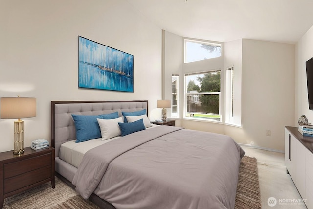 bedroom with light carpet, a towering ceiling, and baseboards