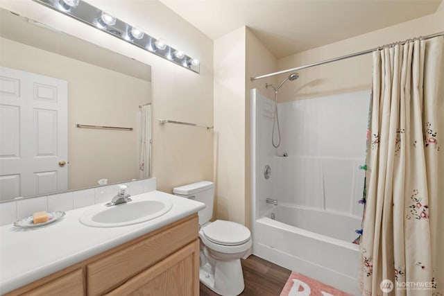 full bathroom with toilet, wood finished floors, shower / bath combination with curtain, and vanity