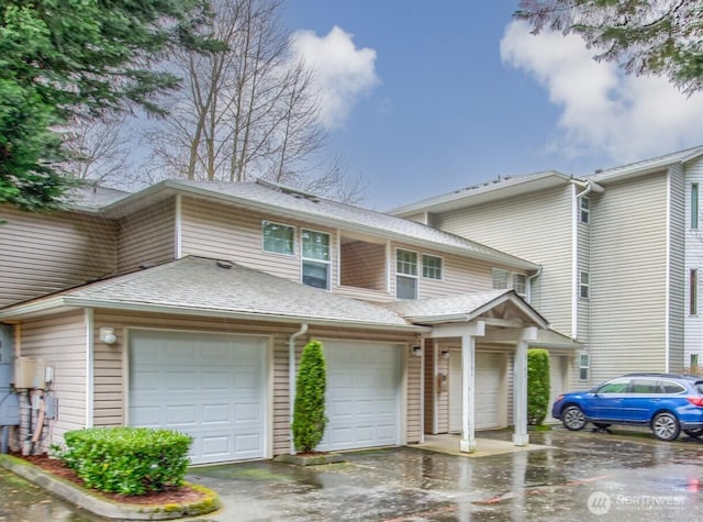 townhome / multi-family property with aphalt driveway and a shingled roof