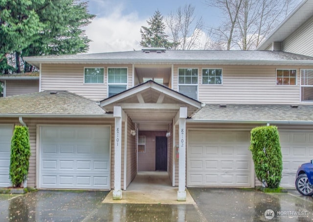 multi unit property with a shingled roof, a garage, and aphalt driveway