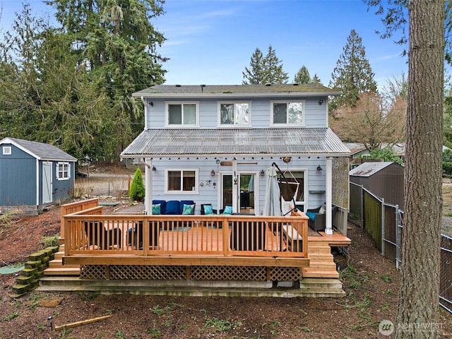 rear view of house featuring a shed, a deck, and an outdoor structure