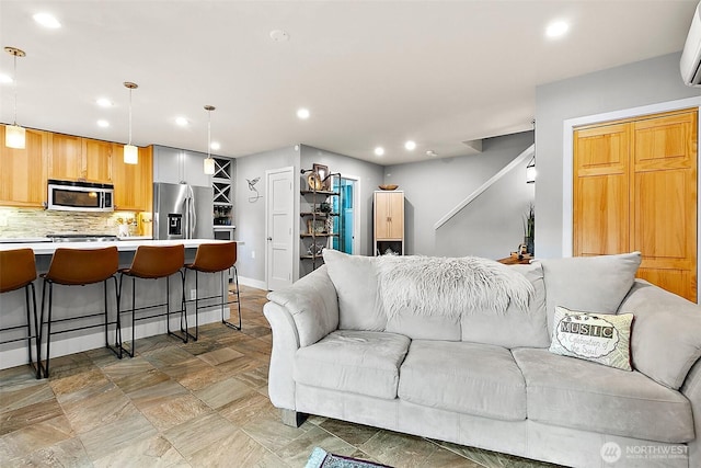 living room featuring baseboards, stairway, an AC wall unit, and recessed lighting