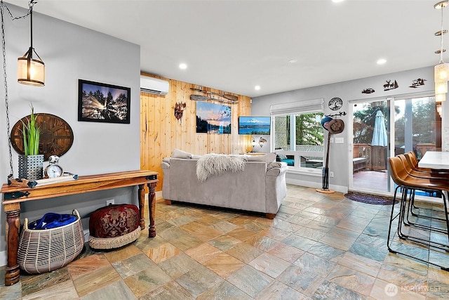 living room featuring recessed lighting, a wall mounted air conditioner, wooden walls, and stone tile floors