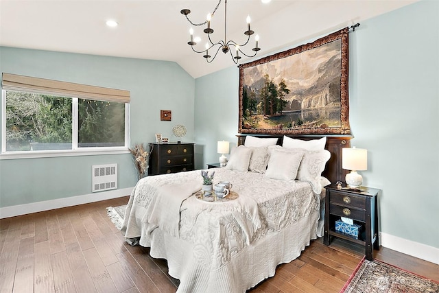 bedroom with vaulted ceiling, baseboards, wood finished floors, and a chandelier