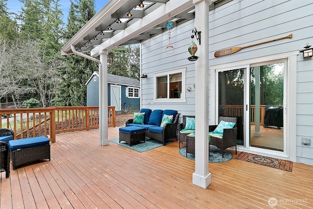 deck featuring a storage shed, an outdoor living space, a pergola, and an outbuilding