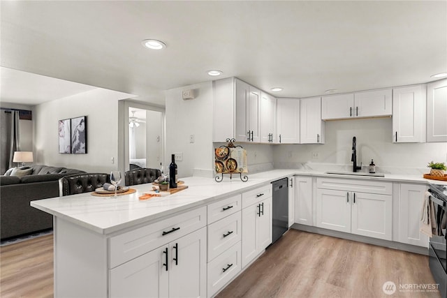 kitchen featuring open floor plan, white cabinetry, dishwasher, and a peninsula