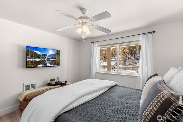 bedroom featuring ceiling fan, baseboards, and wood finished floors