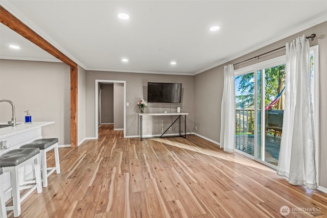 unfurnished living room with light wood-style floors, recessed lighting, crown molding, and baseboards