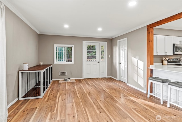 entrance foyer featuring light wood-style flooring, visible vents, and baseboards