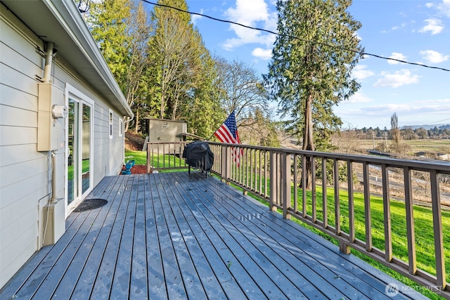 wooden deck featuring a lawn