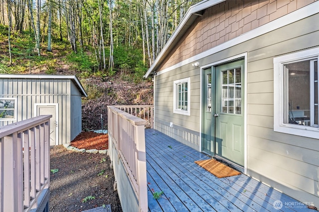 wooden terrace with a storage unit and an outdoor structure