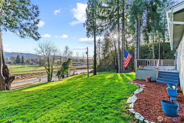 view of yard featuring a deck with mountain view