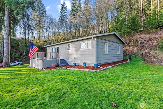 view of front facade featuring a front lawn and a wooden deck