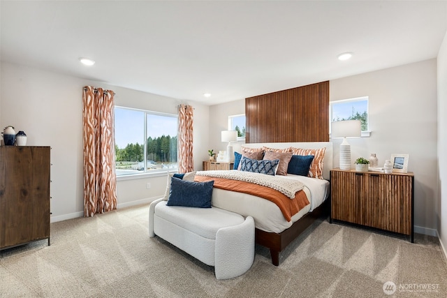 bedroom with radiator, recessed lighting, baseboards, and light colored carpet