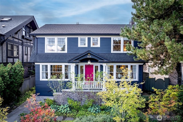 view of front of house featuring roof with shingles, fence, and a chimney