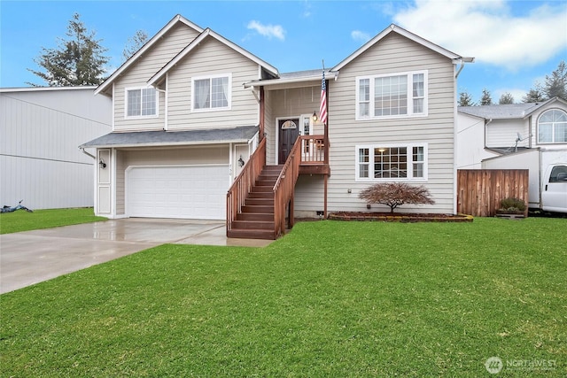 split foyer home with a garage, driveway, a front lawn, and fence