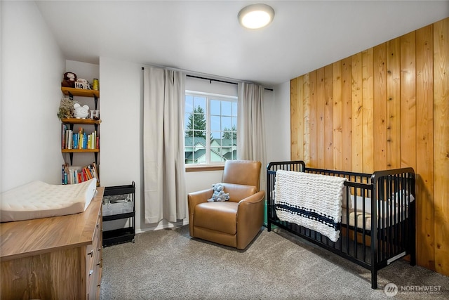 carpeted bedroom with wood walls