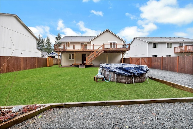 rear view of property with a lawn, a fenced in pool, a fenced backyard, stairs, and a wooden deck