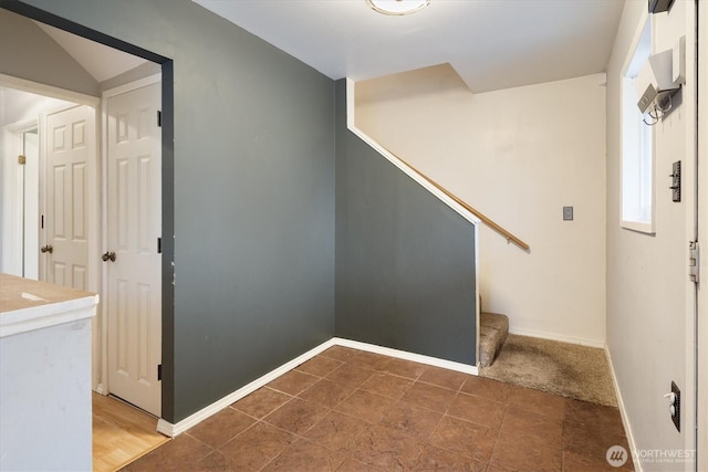 interior space with baseboards and stairway