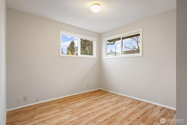 spare room with light wood-style floors and baseboards