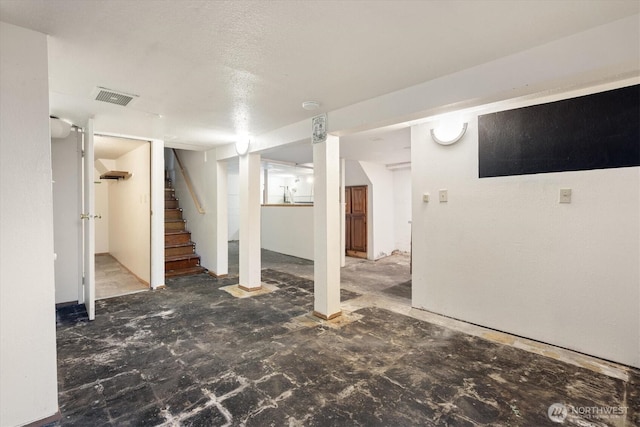 finished basement featuring stairway and visible vents