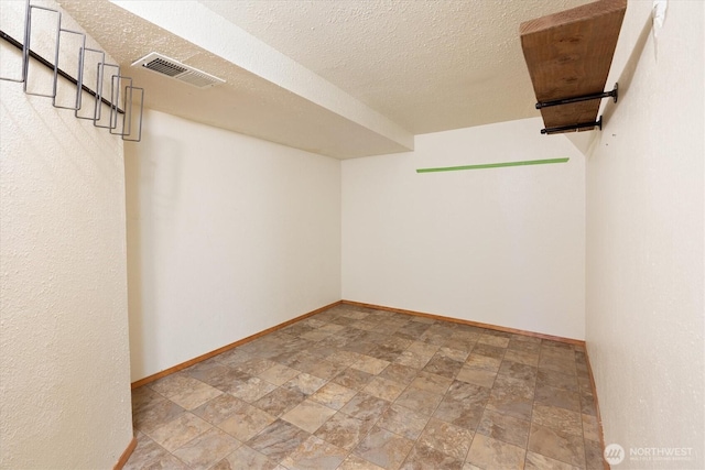 spacious closet with stone finish flooring and visible vents