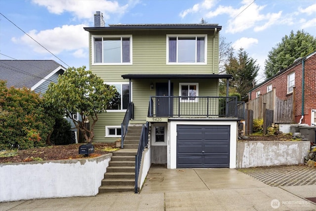 traditional-style house featuring a garage, stairs, a chimney, and concrete driveway