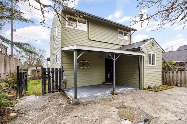 back of property featuring a patio area, fence, and concrete driveway