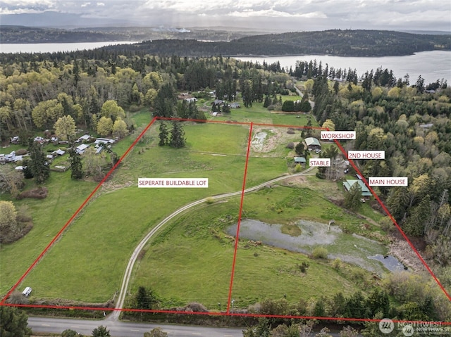 aerial view featuring a water view and a wooded view