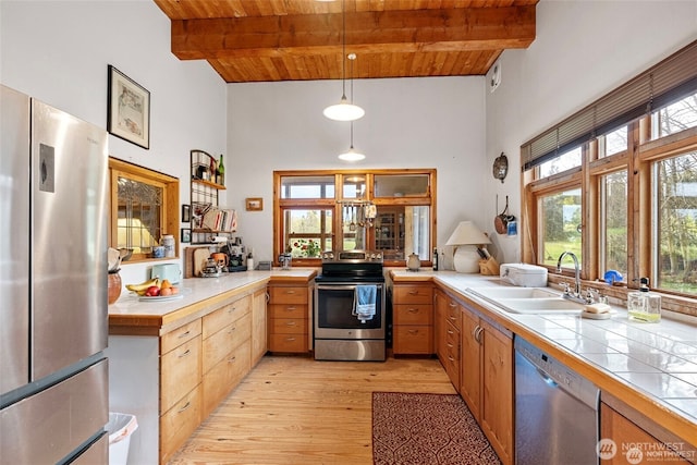 kitchen featuring light wood-style flooring, a sink, wood ceiling, appliances with stainless steel finishes, and beam ceiling