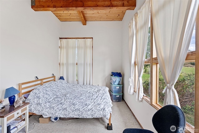 bedroom featuring carpet, multiple windows, wooden ceiling, and beam ceiling