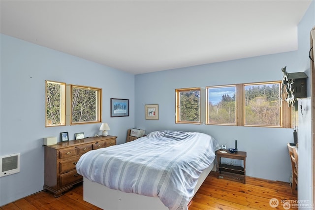 bedroom featuring hardwood / wood-style floors and heating unit