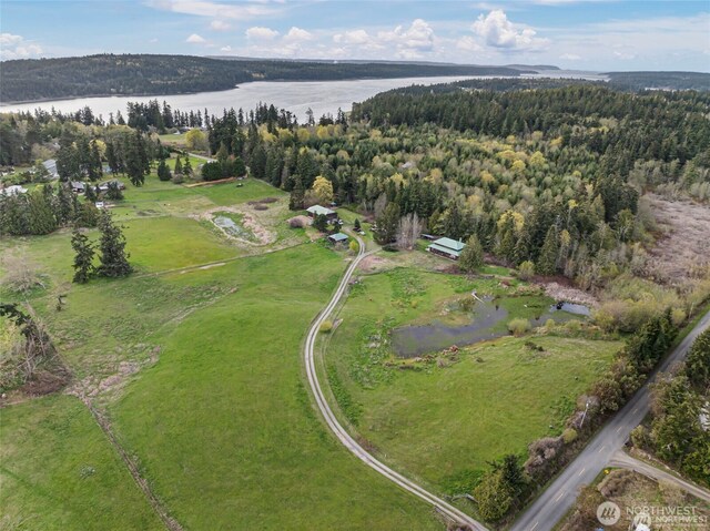 birds eye view of property with a water view and a wooded view