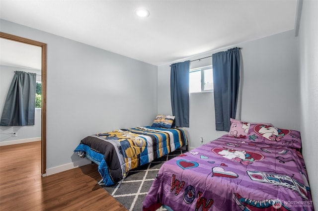 bedroom with baseboards and dark wood finished floors