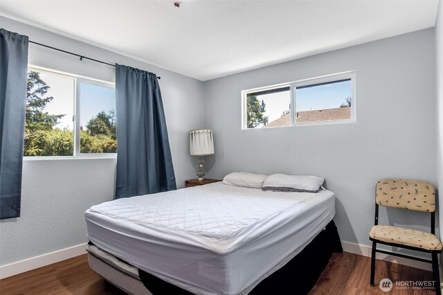 bedroom featuring dark wood finished floors and baseboards