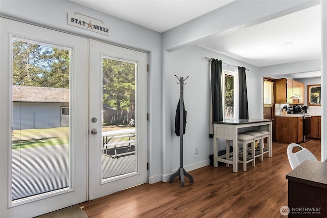 doorway to outside featuring french doors, dark wood finished floors, and baseboards